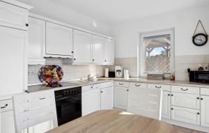a white kitchen with white cabinets and a window at Nice Home In Glowe With Wifi in Glowe +17 photos