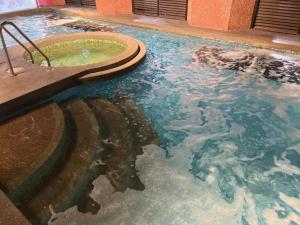 a swimming pool with a tub in the water at Regalodge Hotel & Spa Ipoh in Ipoh