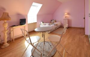 a bedroom with a bed and a table and chairs at Gorgeous Apartment In Le Mesnil-Esnard in Le Mesnil-Esnard