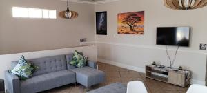 a living room with a couch and a flat screen tv at Pearlman Loft in Tzaneen