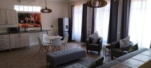 a living room with a couch and a table and a kitchen at Pearlman Loft in Tzaneen