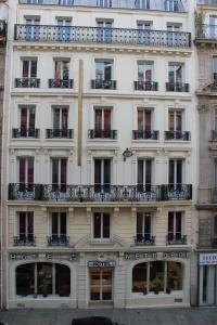 パリにあるメトロポールの窓とバルコニー付きの白い高い建物