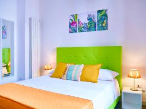 a bed with a green headboard in a room at Qurchiti in Capo dʼOrlando