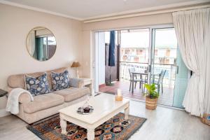 una sala de estar con un sofá y una mesa en Waterfront - Knysna Quays Accommodation, en Knysna