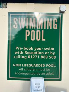 a sign on a wall that says swimming pool at 22 Stowford Gardens Combe Martin in Combe Martin