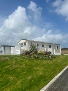 a white house with a white fence and a yard at 22 Stowford Gardens Combe Martin in Combe Martin