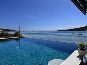 a swimming pool with a view of the water at Segara Seaside Resort in Nusa Lembongan
