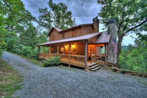 eine Blockhütte im Wald mit einer Flagge in der Unterkunft Pursuit of Happiness Mountain luxury hot tub big-screen TVs pet-friendly in Mineral Bluff