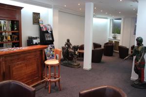 a salon with a bar with a statue of a man at Metropol in Paris