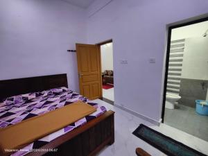 1 dormitorio con 1 cama y puerta al baño en Zilha home stay vagamon, en Vagamon