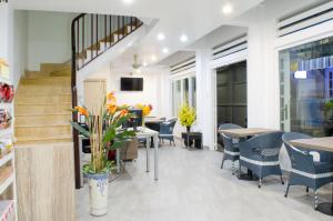 a restaurant with tables and chairs and a staircase at LeBlanc Saigon in Ho Chi Minh City