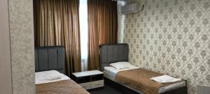 a hotel room with two beds and a window at Эдем in Taraz +7 photos