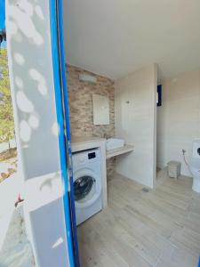 a bathroom with a washing machine and a sink at Emborios Views - Holiday House in Kalymnos