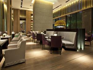Un restaurante con sofás, mesas y sillas. en The East Hotel Hangzhou, en Hangzhou
