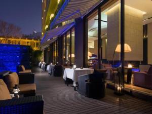 Un restaurante con mesas y sillas en un patio por la noche. en The East Hotel Hangzhou, en Hangzhou