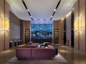 Un vestíbulo con un sofá morado y una pantalla grande. en The East Hotel Hangzhou, en Hangzhou
