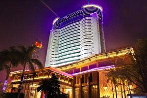 a large building with purple lights on it at night at Cinese Hotel Dongguan in Dongguan