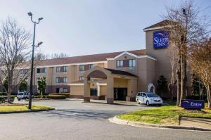 a hotel with a car parked in a parking lot at Sleep Inn Airport - Billy Graham Parkway in Charlotte