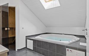 a bath tub in a bathroom with a skylight at Holiday Home Thorsvej Otterup V in Hasmark +18 photos