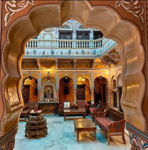 un soggiorno decorato con un arco e mobili di Hotel Radhika Haveli, Mandawa a Mandawa