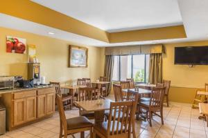 a restaurant with tables and chairs and a television at Quality Inn Calera I-65 exit 231 in Calera