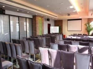 a conference room with chairs and a screen at Grand New Century Hotel Binhai Tianjin in Binhai