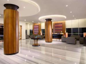 un atrio con colonne di legno in un edificio di Hotel Santika Makassar a Makassar