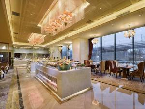 a restaurant with tables and chairs in a building at Beijing Liaoning Hotel in Beijing