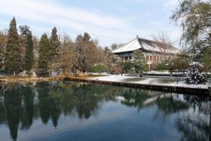 a building and a pond in front of a building at Beijing Liaoning Hotel in Beijing