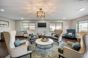 Una sala de estar con sillas, una mesa y un televisor. en Best Western Shelbyville Inn and Suites Celebration Inn, en Shelbyville