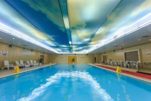 a swimming pool with a ceiling with clouds painted on it at Changsha Xiaoxiang Huatian Hotel in Changsha