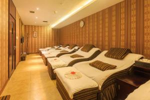 uma fila de camas alinhadas num quarto em Changsha Xiaoxiang Huatian Hotel em Changsha