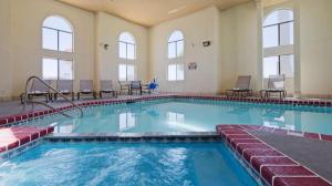 a large swimming pool with chairs in a building at Best Western Windsor Inn in Dumas