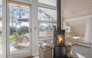 3 Bedroom Cozy Home In Otterup في Otterup: مدفأة في غرفة المعيشة مع إطلالة على الفناء