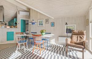 3 Bedroom Cozy Home In Otterup في Otterup: مطبخ وغرفة طعام مع طاولة وكراسي