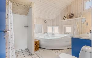 3 Bedroom Cozy Home In Otterup في Otterup: حمام أبيض مع حوض استحمام ومغسلة +17 صورة