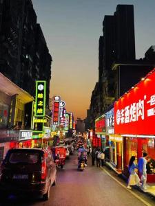 Une rue urbaine animée avec des voitures, des gens et des panneaux dans l'établissement Yueyang Grand Skylight Hotel, à Yueyang