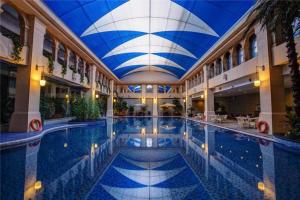 ein großer Pool in einem Gebäude mit blauer Decke in der Unterkunft Shenyang Haiyun Jinjiang International Hotel in Shenyang