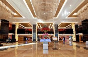 eine große Lobby mit einem großen Kronleuchter in einem Gebäude in der Unterkunft Shenyang Haiyun Jinjiang International Hotel in Shenyang + 170 Fotos
