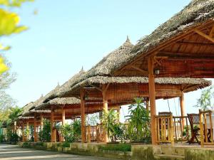 a wooden pavilion with chairs and a thatched roof at My Tra Riverside Hotel in An Bình (1)