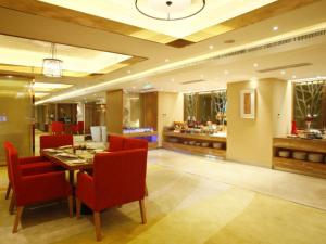 a dining room with a table and red chairs at Howard Johnson by Wyndham Sunshine Plaza Ningbo in Ningbo
