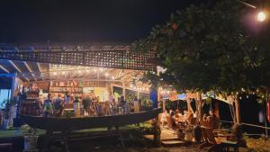 a group of people sitting at a bar at night at JUSH NATIVE AND GLAMPING in Dauis