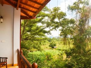 a balcony with a view of a field of trees at Lion Nature in Weliara