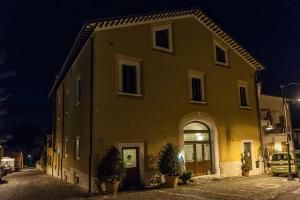 un gran edificio amarillo por la noche en La Locanda di Mariella dal 1950, en Poggio Picenze