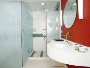 a bathroom with a sink and a shower with a mirror at Hanting Hotel Beijing Summer Palace Branch in Beijing