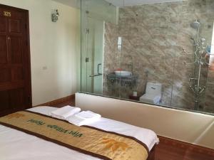 a bathroom with a shower and a bed with towels at Viet Village Hotel in Noi Bai +94 photos
