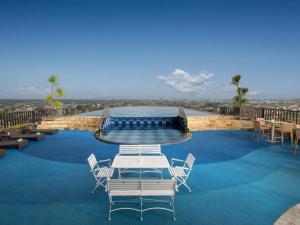 une piscine avec des chaises et une table dessus dans l'établissement Indoluxe Hotel Jogjakarta, à Kejayan