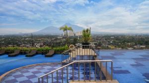 a pool with benches and a view of a city at Indoluxe Hotel Jogjakarta in Kejayan