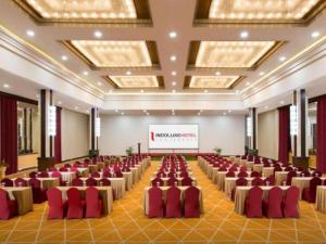 a large banquet hall with red chairs and a screen at Indoluxe Hotel Jogjakarta in Kejayan +106 photos