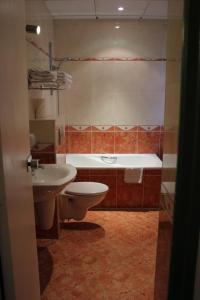 a bathroom with a tub and a toilet and a sink at Metropol in Paris
